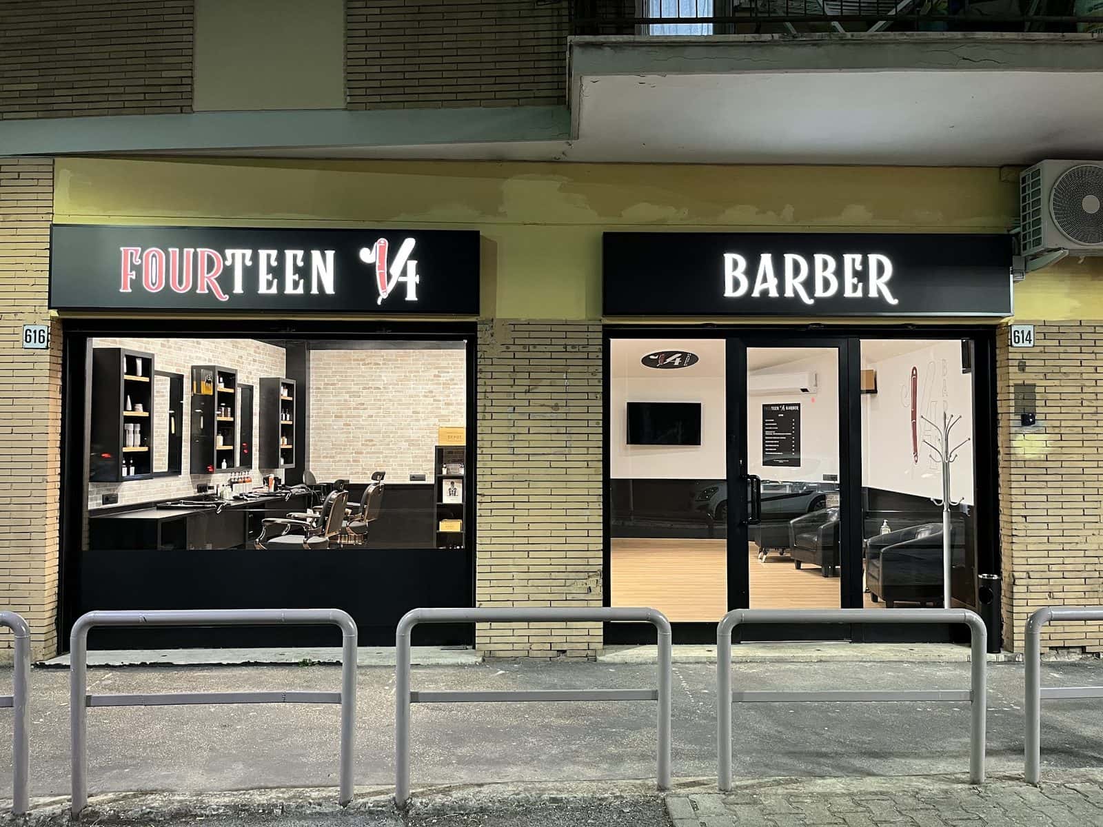 La vetrina di Fourteen 14 Barber in viale Palmiro Togliatti 614-616, con l'insegna accesa